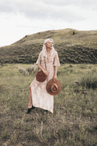 Carly Mal Influencer standing at Knox mountain with dress and hat and purse
