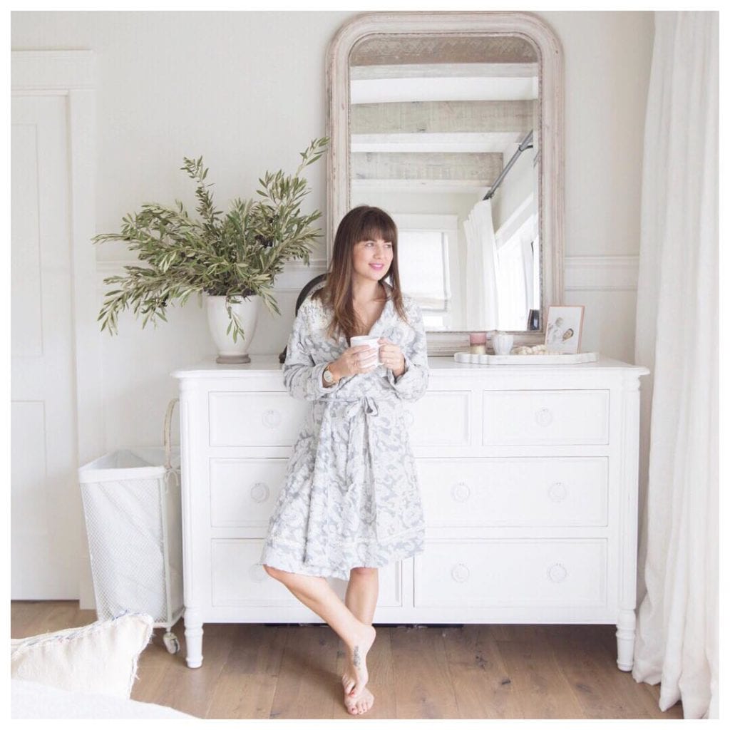 Jillian Harris (@Jillian.Harris) is a fashion influencer and TV star from Vancouver, here she is wearing a pale sundress in a beautiful white bedroom in front of a white dresser